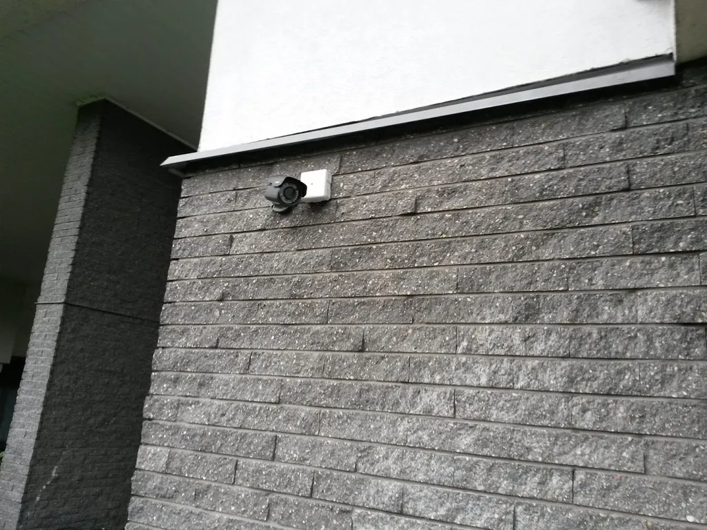 Kamera zamontowana pod okapem domu z elewacją z cegły